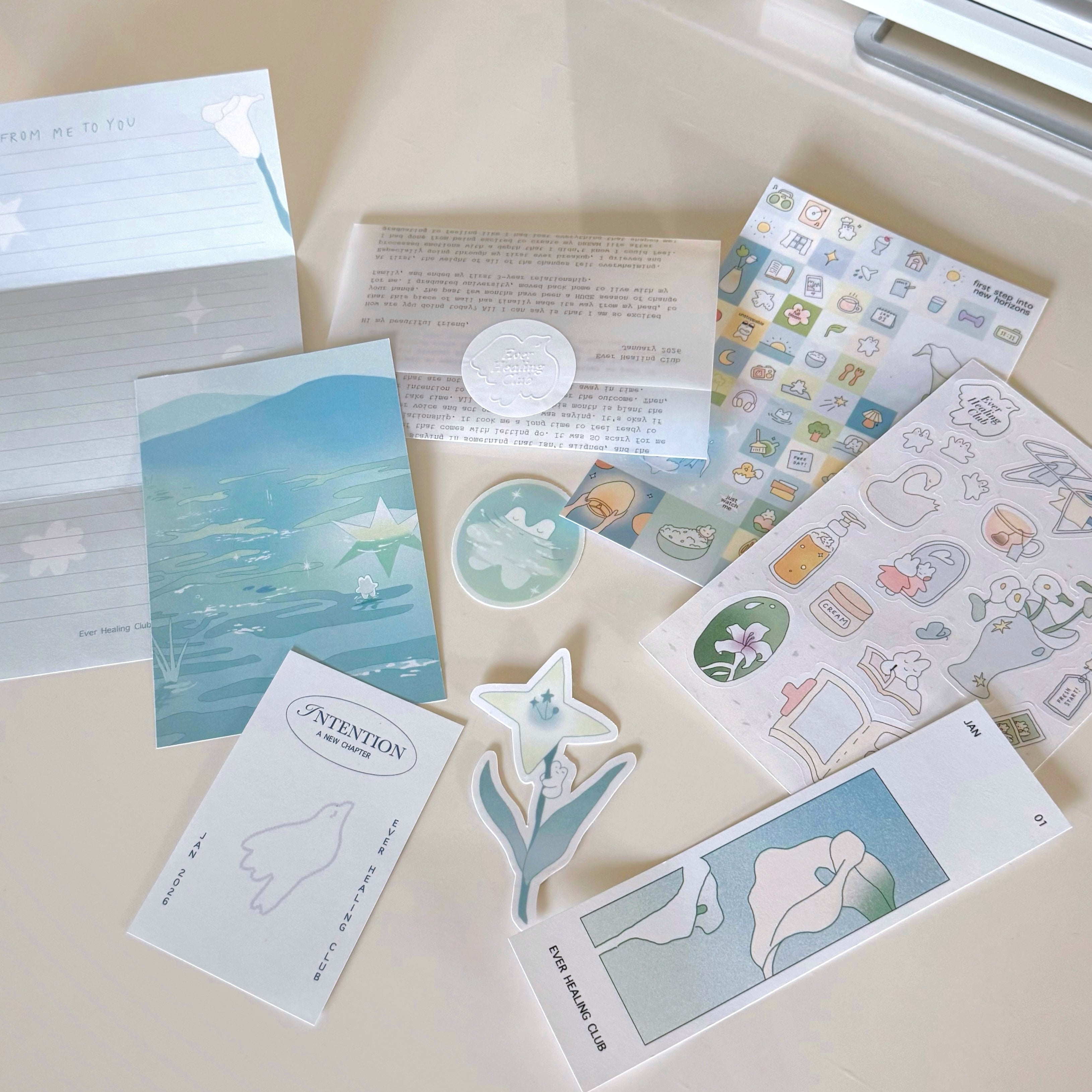 Collection of stationery items including cards and stickers on a light surface. Signature